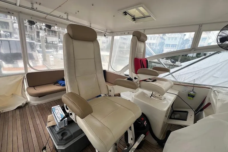 Slide: The Image of 1999 Ocean Yachts 48 Express interior with helm chairs and wooden flooring. - 12