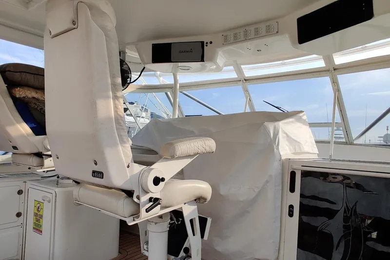 Slide: The Image of 1999 Ocean Yachts 48 Express helm with white seating and navigation equipment. - 13