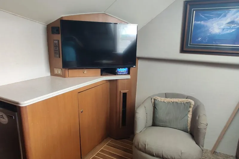 Slide: The Image of Interior of 1999 Ocean Yachts 48 Express with TV, chair, and artwork. - 19