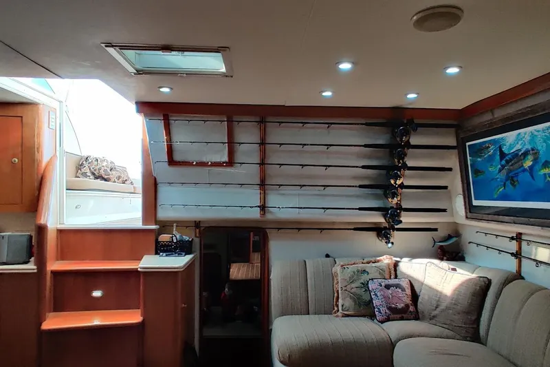 Slide: The Image of Interior of 1999 Ocean Yachts 48 Express with fishing rods and cozy seating area. - 22