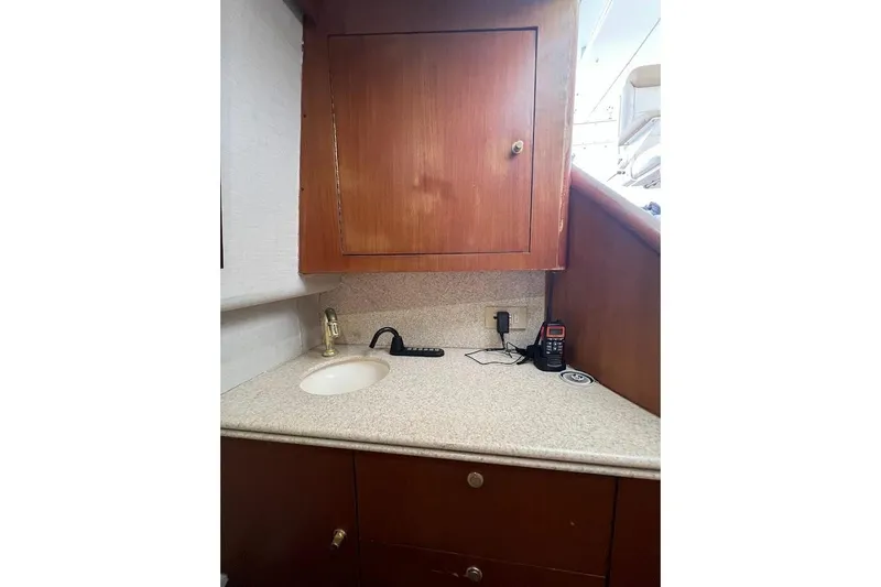 Slide: The Image of 1999 Ocean Yachts 48 Express interior with sink, wooden cabinet, and countertop. - 25