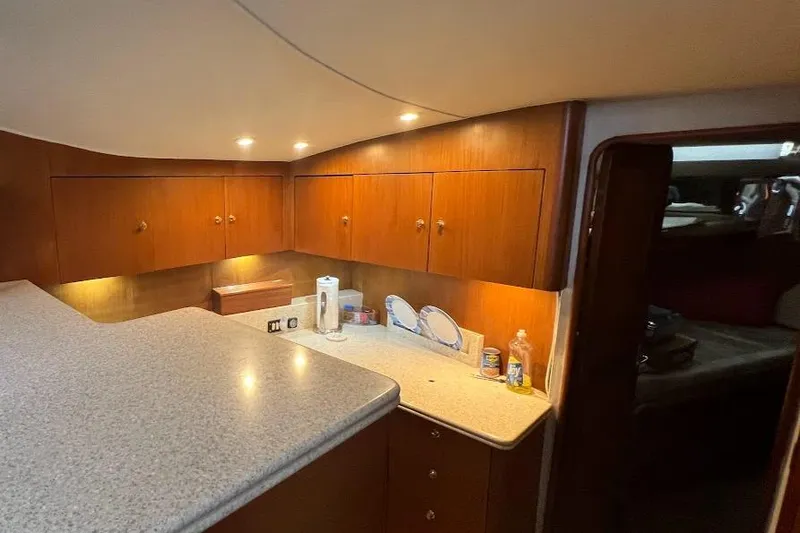 Slide: The Image of Interior of 1999 Ocean Yachts 48 Express with wooden cabinets and countertop. - 28