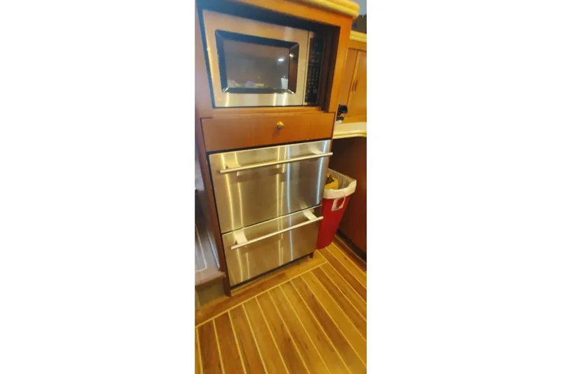 Slide: The Image of 1999 Ocean Yachts 48 Express kitchen with stainless steel appliances and wooden cabinetry. - 29