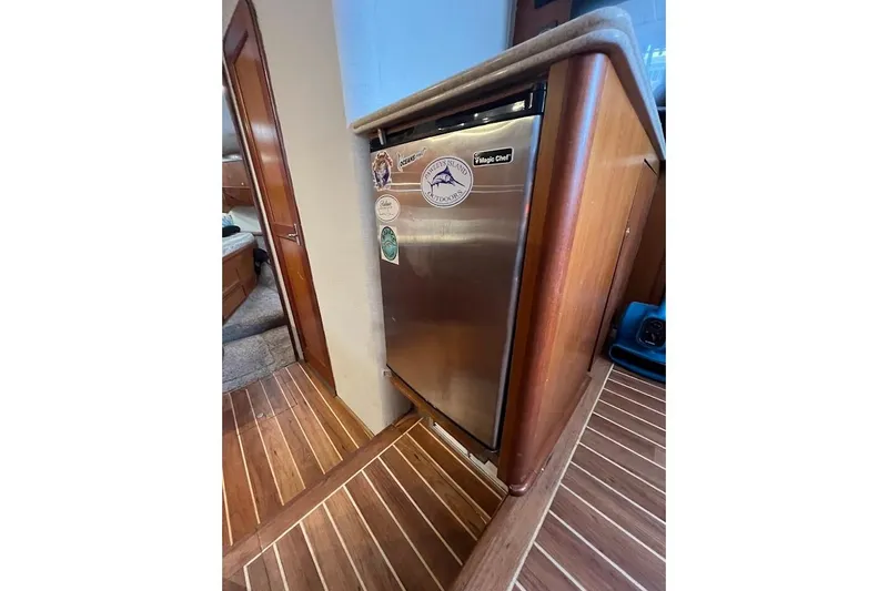 Slide: The Image of 1999 Ocean Yachts 48 Express interior with stainless steel fridge and wooden flooring. - 32
