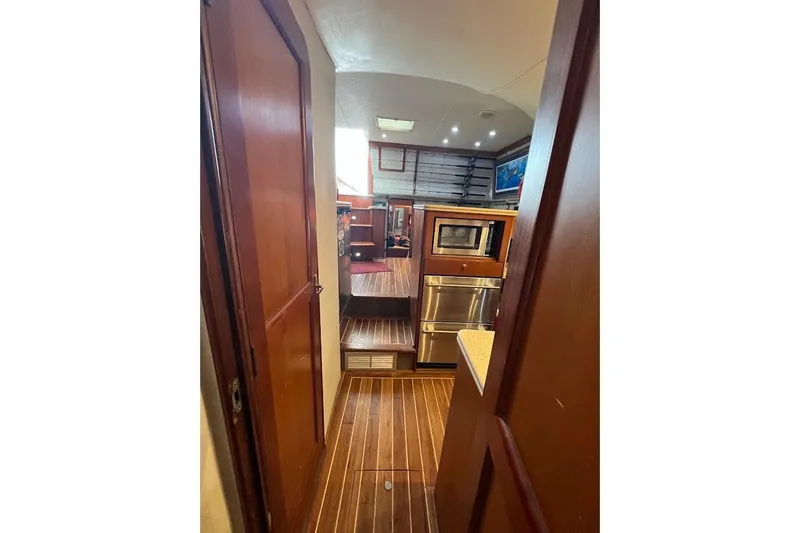 Slide: The Image of Interior of 1999 Ocean Yachts 48 Express, featuring wood paneling and modern kitchen appliances. - 33