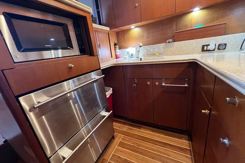 Slide: The Image of 1999 Ocean Yachts 48 Express kitchen with wood cabinetry, stainless steel appliances, and modern fixtures. - 34