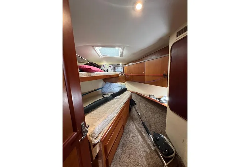 Slide: The Image of 1999 Ocean Yachts 48 Express cabin interior with bunk beds and wooden storage cabinets. - 35