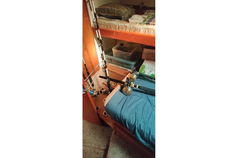 Slide: The Image of Interior of 1999 Ocean Yachts 48 Express with fishing rods and bunk beds. - 39