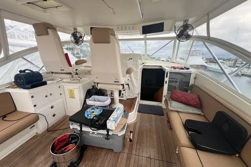 Slide: The Image of 1999 Ocean Yachts 48 Express interior with seating, helm, and marina view. - 4