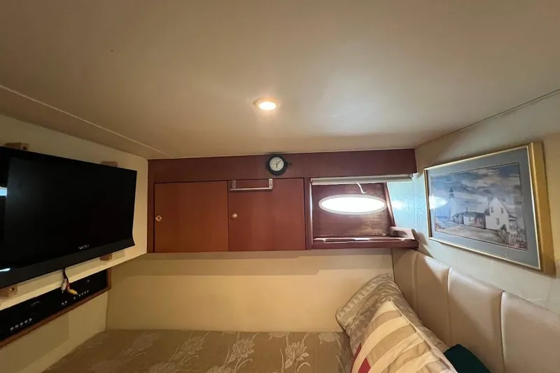 Slide: The Image of Interior of 1999 Ocean Yachts 48 Express with TV, artwork, and wooden cabinets. - 42