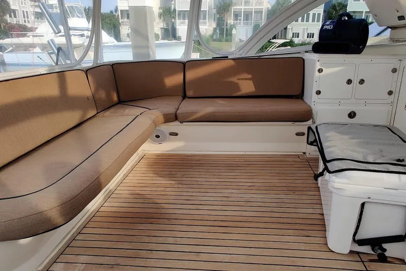 Slide: The Image of 1999 Ocean Yachts 48 Express interior with cushioned seating and wooden flooring. - 5