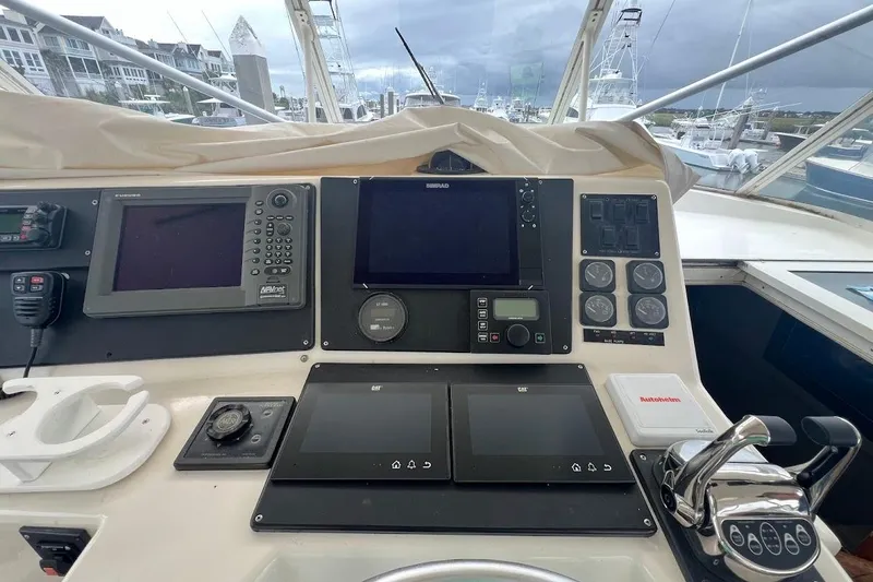 Slide: The Image of 1999 Ocean Yachts 48 Express helm with navigation equipment and controls, docked at marina. - 6