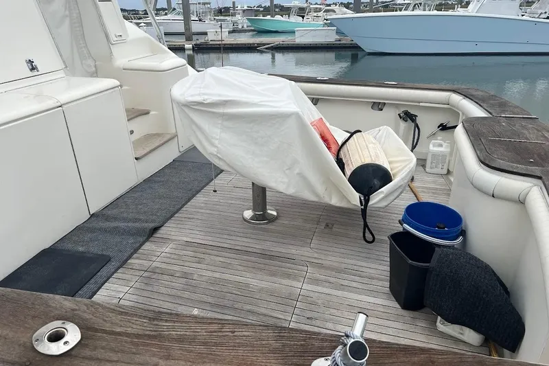 Slide: The Image of 1999 Ocean Yachts 48 Express boat deck with covered seating and docked vessels in background. - 60