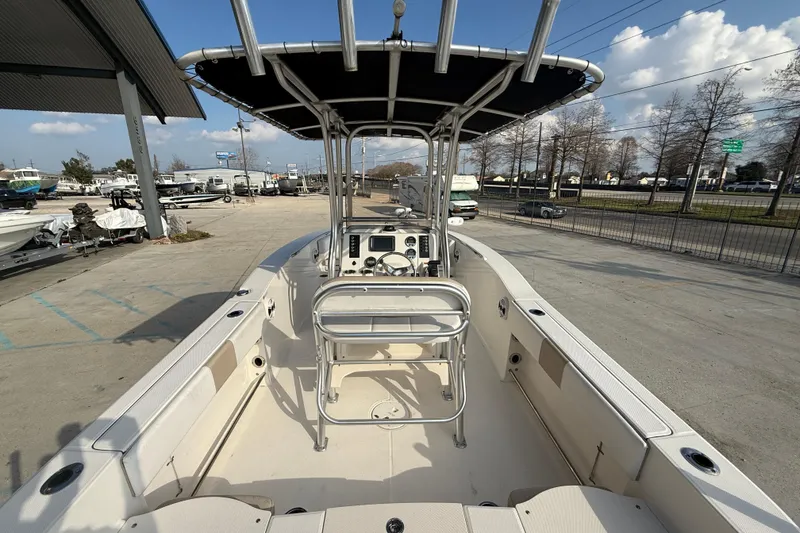 Slide: The Image of 2018 Robalo R200 Center Console boat with T-top, parked outdoors under a blue sky. - 7