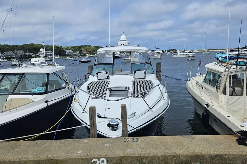 Slide: The Image of 2010 Formula 34 Performance Cruiser docked between boats in a scenic harbor. - 2