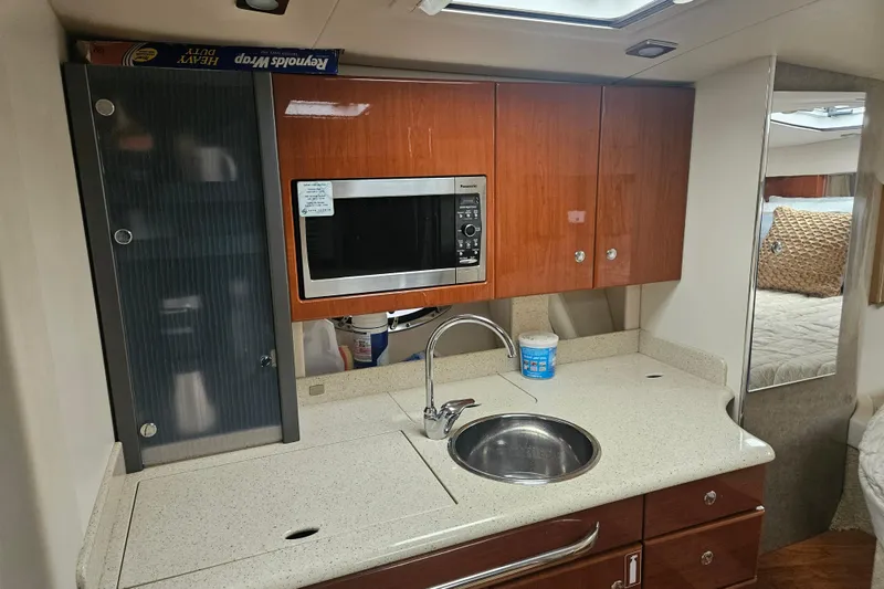 Slide: The Image of 2010 Formula 34 Performance Cruiser kitchen with microwave, sink, and wooden cabinets. - 45