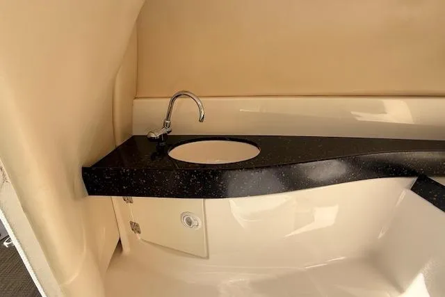 Slide: The Image of 2013 Regal 2500 Bowrider interior with sleek black countertop and modern sink. - 13