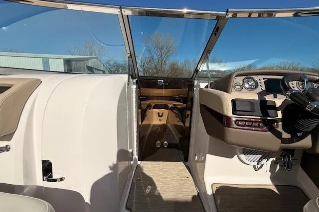 Slide: The Image of 2013 Regal 2500 Bowrider cockpit with steering wheel and dashboard under clear blue sky. - 14