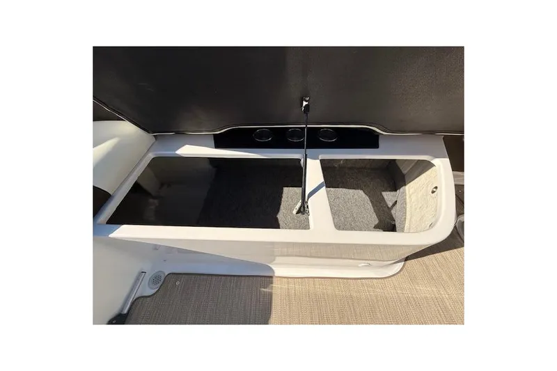 Slide: The Image of 2013 Regal 2500 Bowrider storage compartment with open lid and carpeted interior. - 23