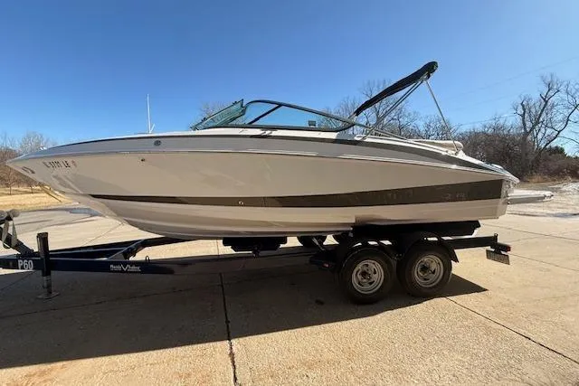 Slide: The Image of 2013 Regal 2500 Bowrider boat on trailer under clear blue sky. - 3