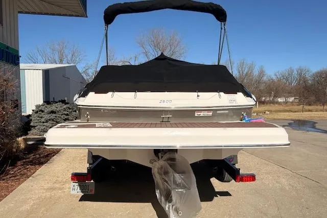 Slide: The Image of 2013 Regal 2500 Bowrider boat with black cover, parked on a sunny day. - 38