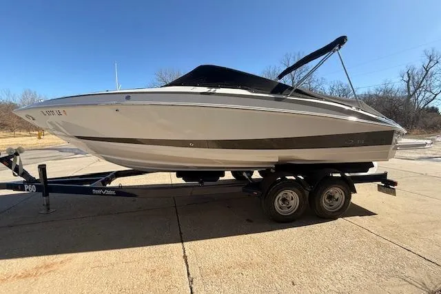 Slide: The Image of 2013 Regal 2500 Bowrider boat on trailer, parked outdoors under clear sky. - 39