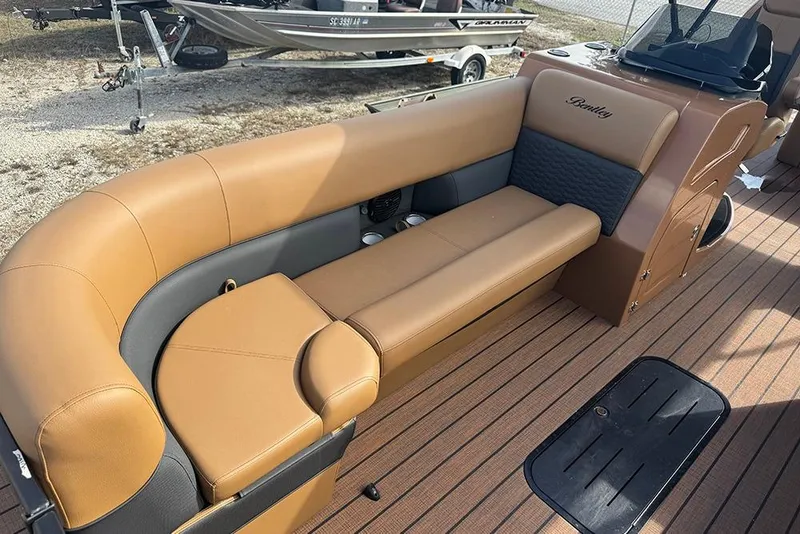 Slide: The Image of 2026 Bentley Pontoons Elite 253 Swingback interior with tan seating and dual captain setup. - 15