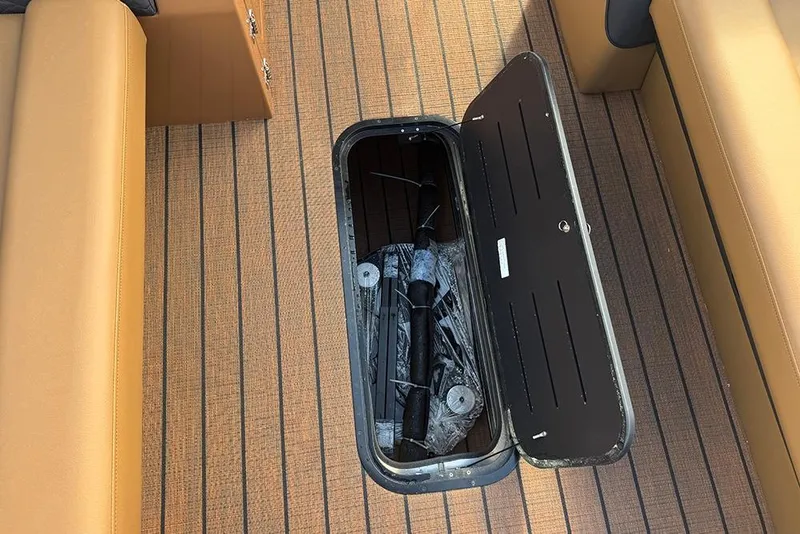 Slide: The Image of 2026 Bentley Pontoons Elite 253 Swingback Tritoon with open storage compartment on deck. - 18