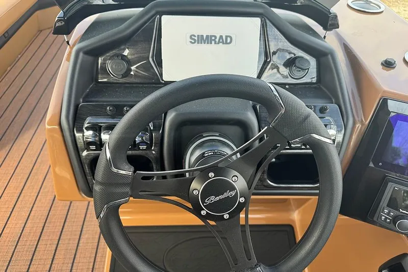 Slide: The Image of 2026 Bentley Pontoons Elite 253 dashboard with Simrad display and steering wheel. - 21