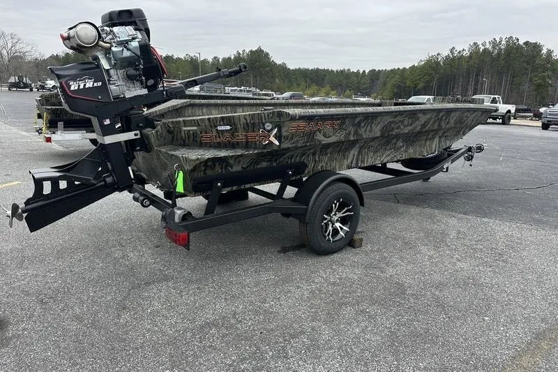 Slide: The Image of 2026 SeaArk 1752 Slayer X boat on trailer, camo design, parked outdoors. - 3