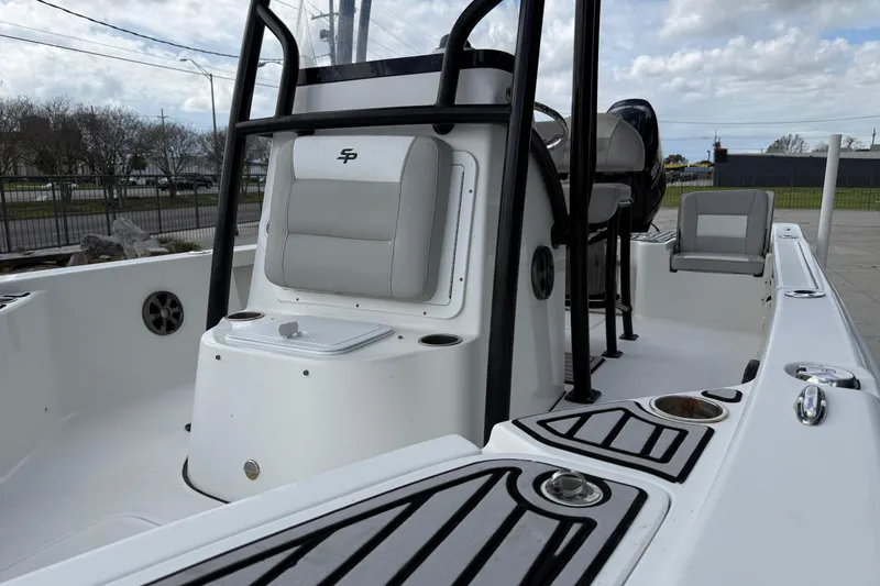 Slide: The Image of 2018 Sea Pro 228 Bay boat interior with seating and console, under cloudy sky. - 10