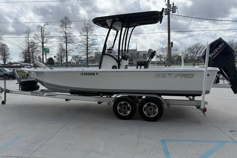 Slide: The Image of 2018 Sea Pro 228 Bay boat on trailer, parked outdoors under cloudy sky. - 5