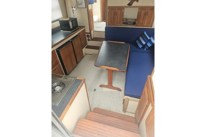 Slide: The Image of Interior of a 1998 Nordic Tug 32, featuring a cozy dining area and compact kitchen. - 13