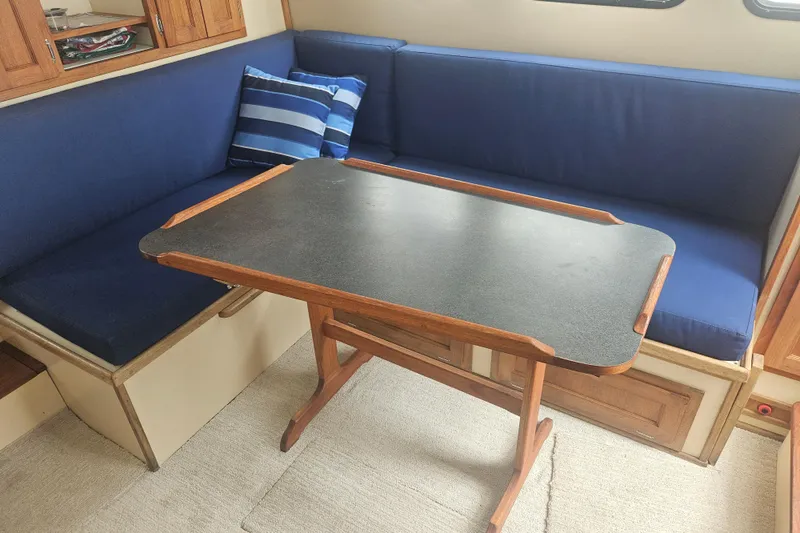 Slide: The Image of Cozy interior of a 1998 Nordic Tug 32 with blue seating and wooden table. - 15