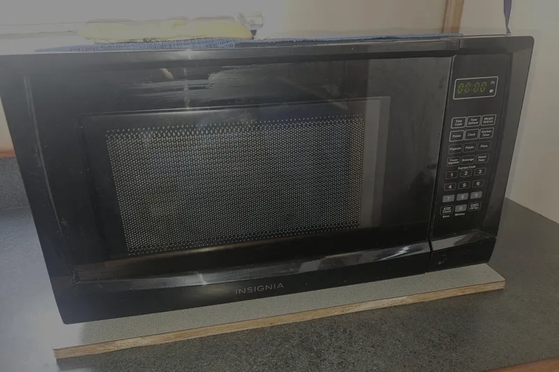 Slide: The Image of Black Insignia microwave on a countertop inside a 1998 Nordic Tug 32 boat. - 19