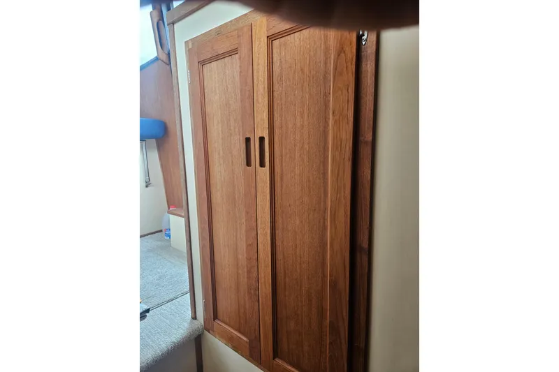 Slide: The Image of Wooden cabinet doors inside a 1998 Nordic Tug 32 boat interior. - 20