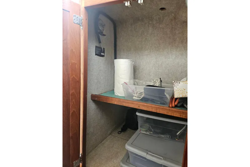Slide: The Image of Storage compartment inside a 1998 Nordic Tug 32, featuring shelves and organized containers. - 21