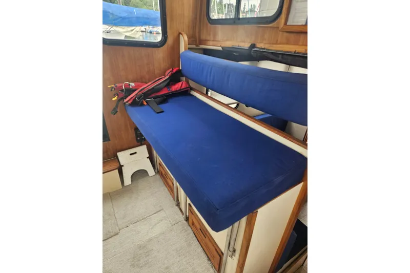 Slide: The Image of Interior of 1998 Nordic Tug 32 with blue cushioned seating and wooden accents. - 26