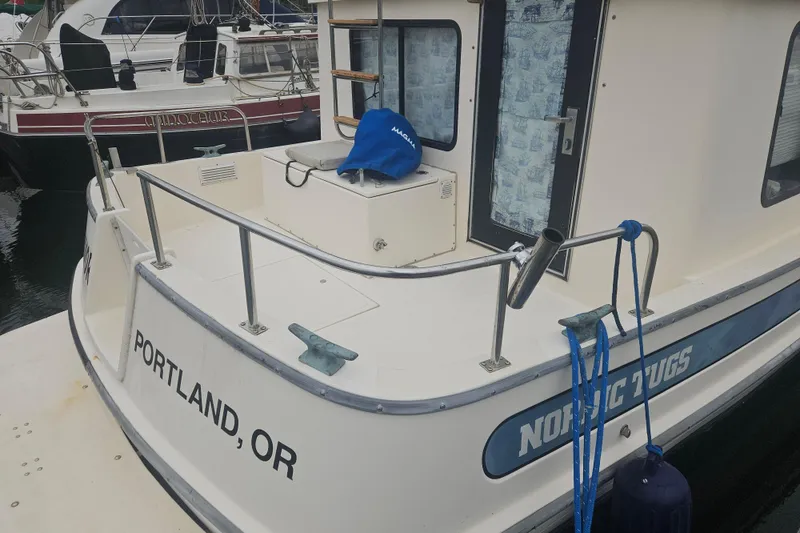 Slide: The Image of 1998 Nordic Tug 32 docked in Portland, OR, featuring a clean deck and railing. - 3