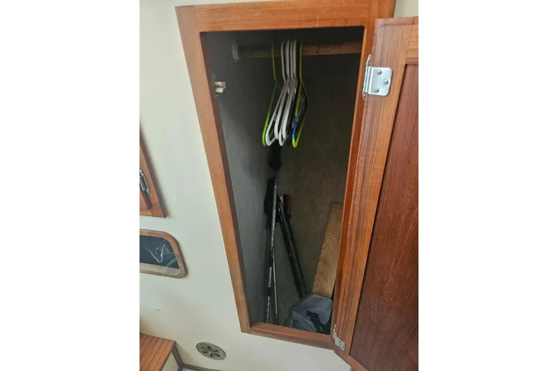 Slide: The Image of Open wooden closet on 1998 Nordic Tug 32 boat with hangers and storage space. - 38