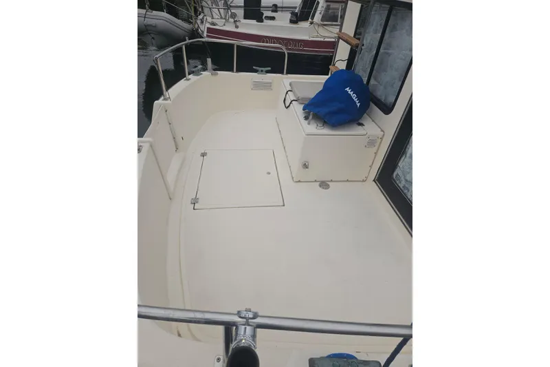Slide: The Image of 1998 Nordic Tug 32 boat deck with storage hatch and covered equipment. - 4