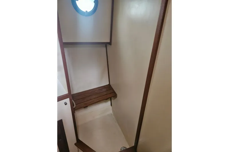 Slide: The Image of Interior of 1998 Nordic Tug 32, featuring a wooden bench and porthole. - 41