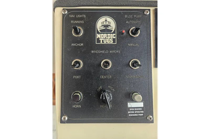 Slide: The Image of Control panel of a 1998 Nordic Tug 32 boat with various switches and labels. - 43