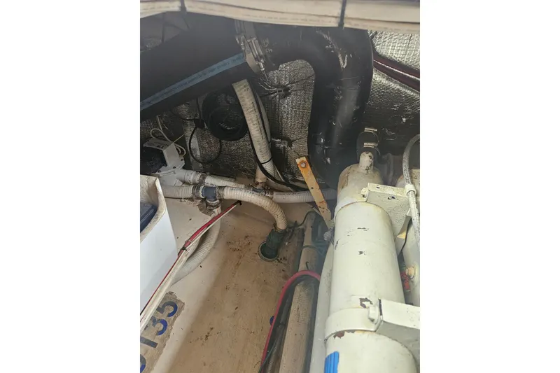 Slide: The Image of Engine room of a 1998 Nordic Tug 32, showing pipes and mechanical components. - 49