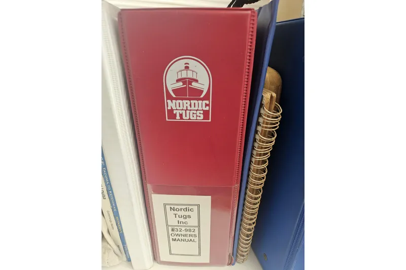 Slide: The Image of Red binder with Nordic Tugs logo, containing 1998 Nordic Tug 32 owner's manual. - 58