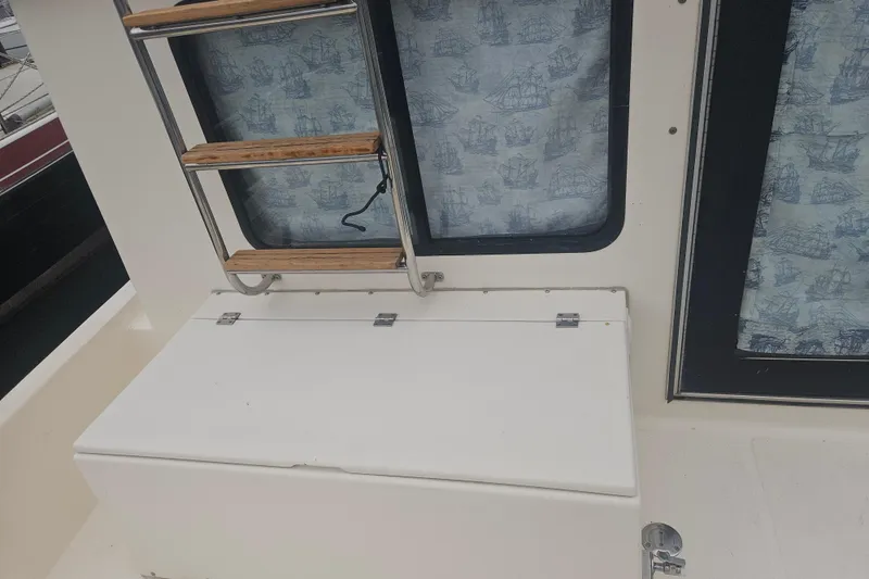 Slide: The Image of 1998 Nordic Tug 32 boat interior with wooden ladder and nautical-themed curtains. - 7