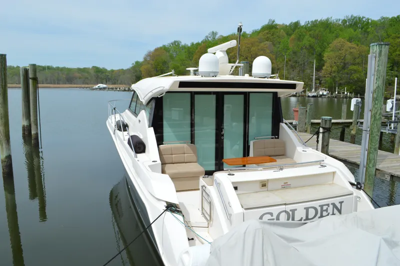Slide: The Image of 2017 Tiara Yachts C44 Coupe docked, serene water setting. - 16