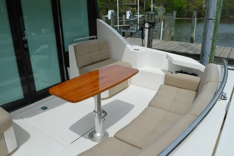 Slide: The Image of 2017 Tiara Yachts C44 Coupe, elegant outdoor seating with wooden table. - 17