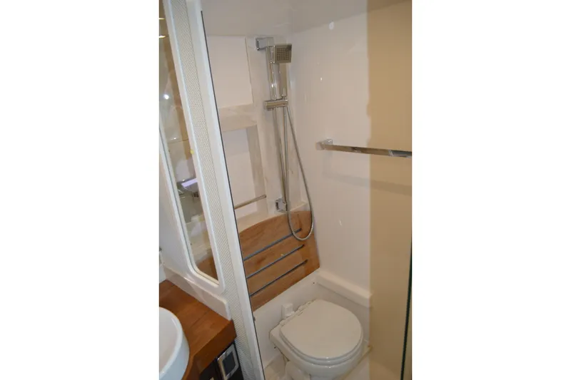 Slide: The Image of 2017 Tiara Yachts C44 Coupe bathroom with shower, toilet, and wooden accents. - 50