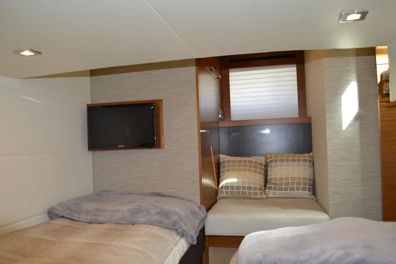 Slide: The Image of 2017 Tiara Yachts C44 Coupe cabin interior with beds, TV, and modern decor. - 55